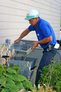 AC-technician-opening-the-condenser-unit-to-look-at-the-compressor