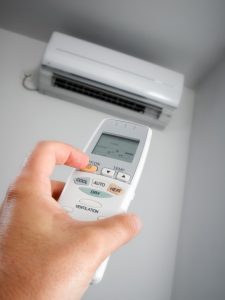 person-pointing-remote-at-ductless-air-handler